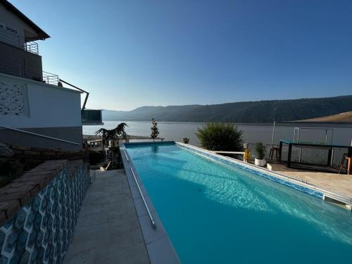 een groot zwembad met uitzicht op het water bij Riviera 990 - Resort & Restaurant in Eşelniţa
