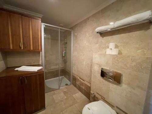 y baño con aseo y ducha acristalada. en Gold city Alanya - 5 star two bedroom hotel apartment with full Sea view, en Alanya
