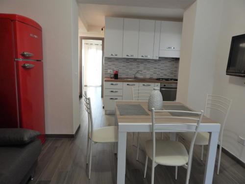 a kitchen with a table and chairs and a red refrigerator at Casa Foddis - Bed and View in Baunei