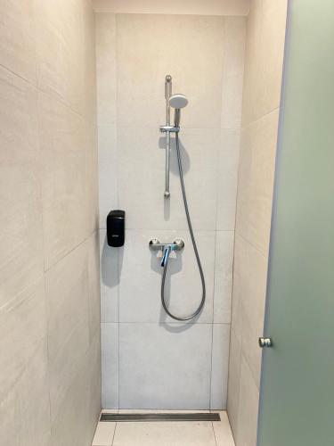 a shower with a shower head in a bathroom at AtmoSphere Apartment by Infinity Resort & Spa in Mamaia Nord
