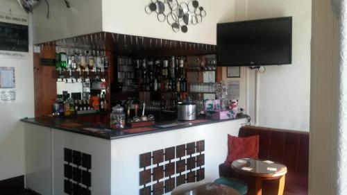 a bar in a restaurant with a television above it at Sharn Bek Hotel in Blackpool