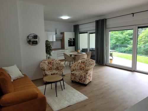 ein Wohnzimmer mit einem Sofa, Stühlen und einem Tisch in der Unterkunft Villa LOE in Villach