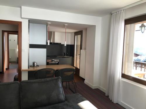 un salon avec un canapé et une cuisine dans l'établissement La maison de Cécile, à Ventron