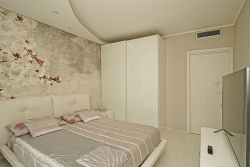 Schlafzimmer mit einem Bett und einem TV in der Unterkunft La Castellana C89 by Wonderful Italy in Sirmione