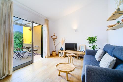 un salon avec un canapé bleu et une table dans l'établissement Surmar - Apartamento con piscina en Cap d'Artrutx, à Cala'n Bosch