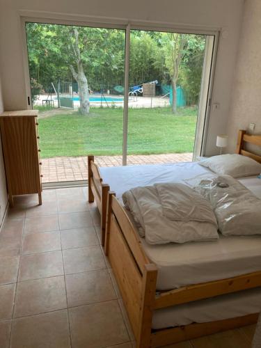 - une chambre avec un lit et une grande fenêtre dans l'établissement Villa les Platanes Aix en Provence, à Aix-en-Provence