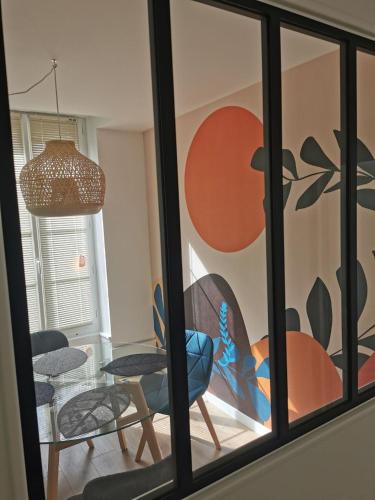 a room with a window with a chair and a table at Les clos de Givry - Clos Léonie - Appartement 68m2 spacieux, lumineux et avec sauna in Givry