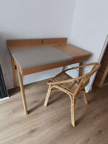 a wooden table and a chair next to a desk at Les clos de Givry - Clos Léonie - Appartement 68m2 spacieux, lumineux et avec sauna in Givry