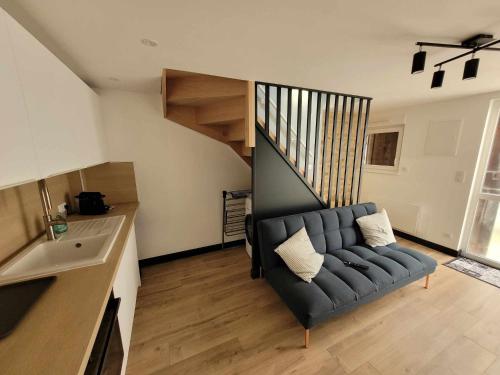 a living room with a couch and a staircase at Duplex Mon Désert - Parc Sainte Marie - Nancy Thermal in Nancy
