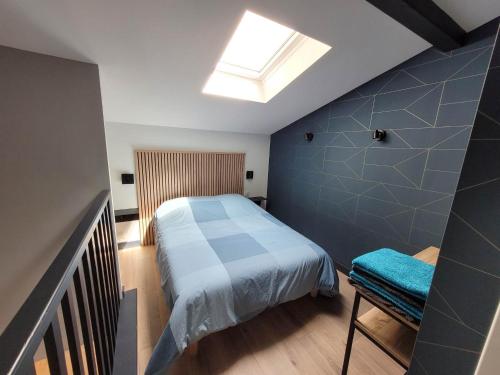 een kleine slaapkamer met een bed en een dakraam bij Duplex Mon Désert - Parc Sainte Marie - Nancy Thermal in Nancy