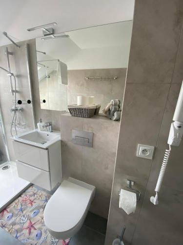a bathroom with a white toilet and a sink at NATURAvistaMARE I in Dziwnów