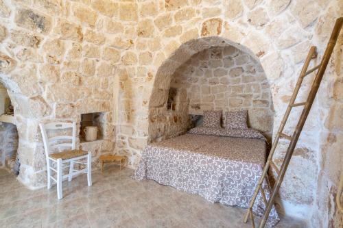 1 dormitorio con 1 cama en una pared de piedra en Bouganvillea Villa in Ostuni, en Ostuni