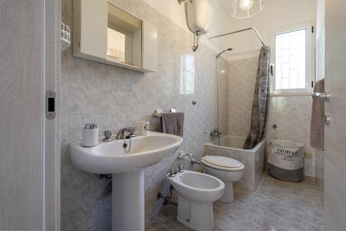 Baño blanco con lavabo y aseo en Bouganvillea Villa in Ostuni, en Ostuni