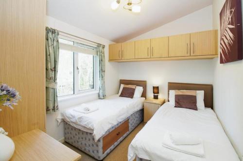 two beds in a small room with a window at 10 Trehawks in Wadebridge