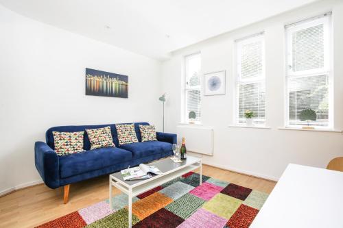 a living room with a blue couch and a table at Perfect City Centre Location - Historic Albion Mews in Chester