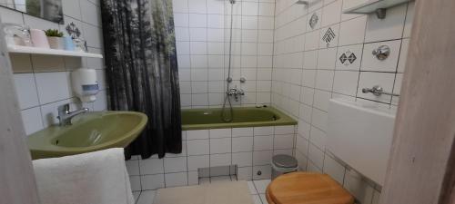 W łazience znajduje się zielona umywalka i wanna. w obiekcie BELYSIUM Bed & Breakfast Panzió w Gyenesdiás