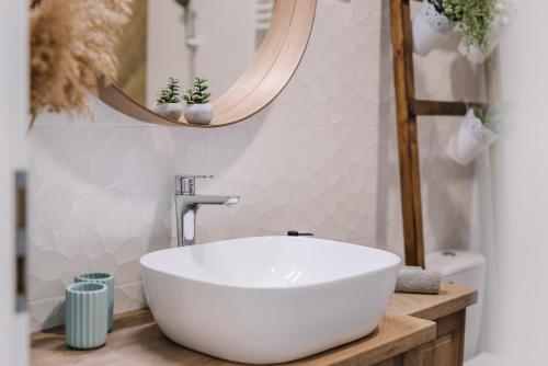 a bathroom with a white sink and a mirror at Nádas Center Home Badacsony in Badacsonytomaj