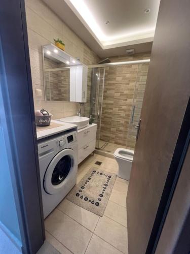 a bathroom with a washing machine and a toilet at Akrotiri Luxury Suites in Trápeza