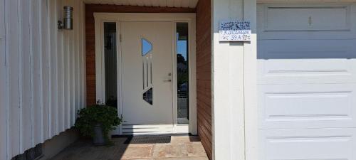 Una porta bianca per una casa con un cartello sopra di Rum i Villa a Jönköping