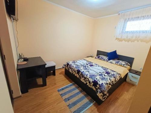 um quarto com uma cama, uma secretária e uma mesa em Casa Simona em Botiz