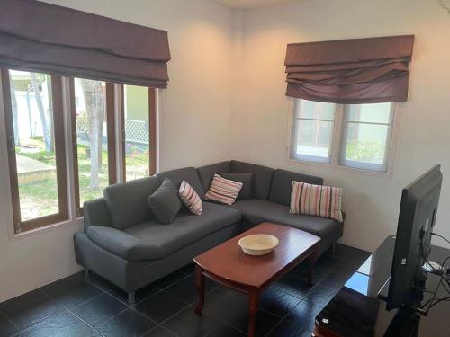 ein Wohnzimmer mit Sofa und Tisch in der Unterkunft Loma-asunto Hua Hin Soi 94 Baan Finland apartment 28 in Hua Hin