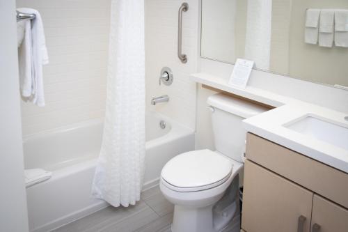 a white bathroom with a toilet and a sink at Candlewood Suites Miami Intl Airport - 36th St by IHG in Miami