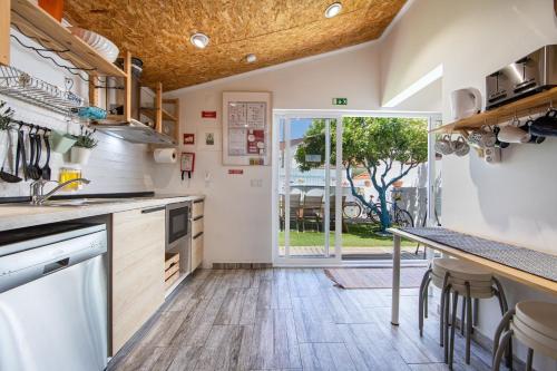 a kitchen with wooden floors and a large window at Vila Maria Mix Dorm by HOST-POINT in Costa da Caparica