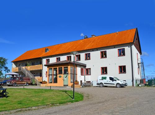 un grand bâtiment blanc avec un toit orange dans l'établissement Tostarps Pensionat, à Hässleholm