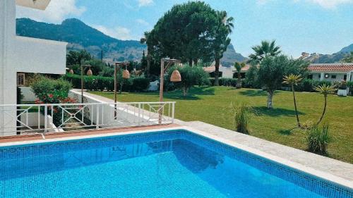 a swimming pool in front of a house with a yard at Villa Rizia in Kolymbia