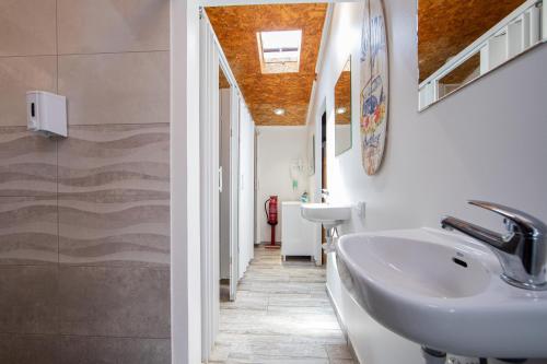a bathroom with a sink and a mirror at Vila Maria Mix Dorm by HOST-POINT in Costa da Caparica