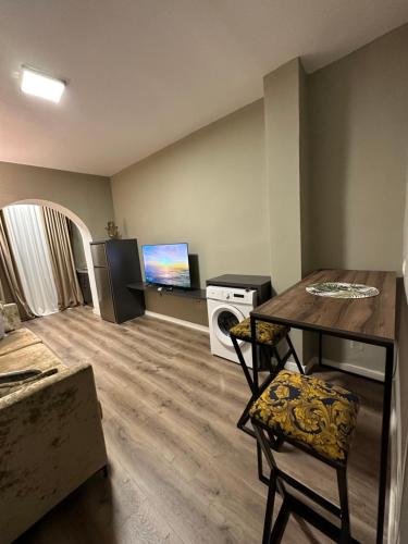 Bejart Apartment 4 في تيرانا: غرفة معيشة مع طاولة وتلفزيون