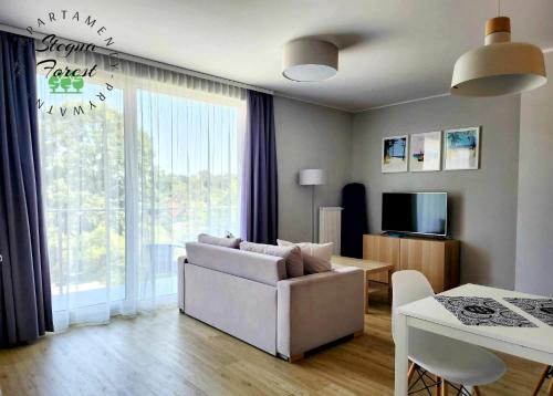 un soggiorno con divano bianco e tavolo di Apartamenty Prywatne w Stegna Forest a Stegna