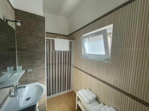 La salle de bains est pourvue d'un lavabo et d'une fenêtre. dans l'établissement Casa ALCA, à Acquavella