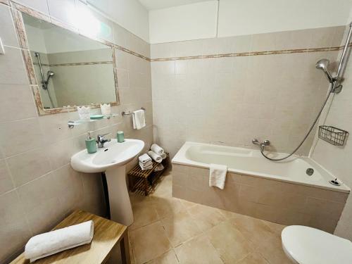 une salle de bain avec un lavabo, une baignoire et des toilettes dans l'établissement Villa Acula Marina, à Lucciana