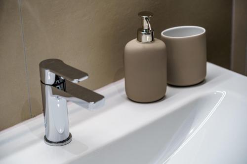 a sink with a faucet and a soap dispenser on it at Heart of Interlaken Apartments in Interlaken