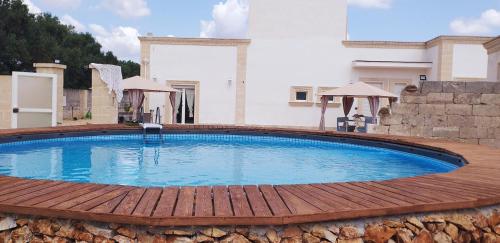 une grande piscine entourée d'une terrasse en bois. dans l'établissement Dimora Aminidelo, à Maruggio