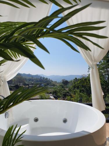 a bath tub with a palm tree in the foreground at เฌอปือ เชียงใหม่ Cherpue Chiangmai in Ban Mae Na