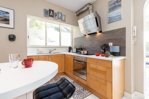 une cuisine avec des armoires en bois et un comptoir blanc dans l'établissement VILLA CRUG HYWEL - VILLEFRANCHE-SUR-MER, à Villefranche-sur-Mer