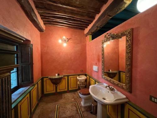 ein Badezimmer mit einem Waschbecken, einem WC und einem Spiegel in der Unterkunft Suite Il Focolare, Villa Nemora in Castello di Montalto