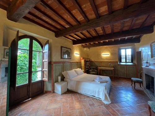 ein Schlafzimmer mit einem Bett und einem Kamin in der Unterkunft Suite Il Focolare, Villa Nemora in Castello di Montalto