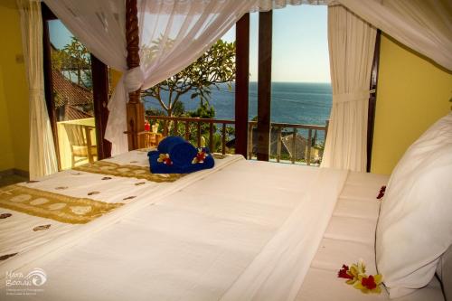 a bedroom with a bed with a view of the ocean at Beten Waru Bungalow and Restaurant in Amed