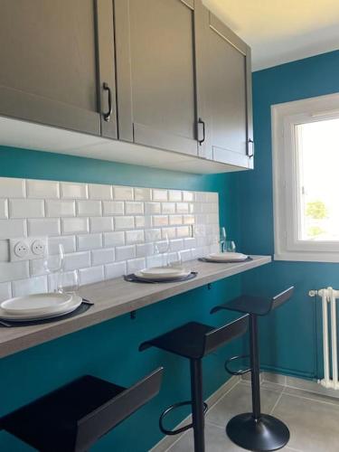 une cuisine bleue avec deux éviers et deux tabourets de bar dans l'établissement Appartement neuf, 3 chambres avec vue panoramique, au Mans