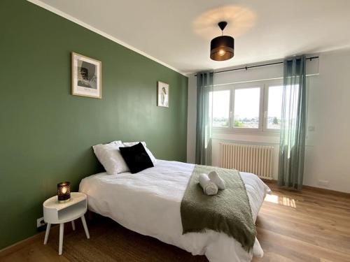 une chambre avec un grand lit avec un mur végétal dans l'établissement Appartement neuf, 3 chambres avec vue panoramique, au Mans