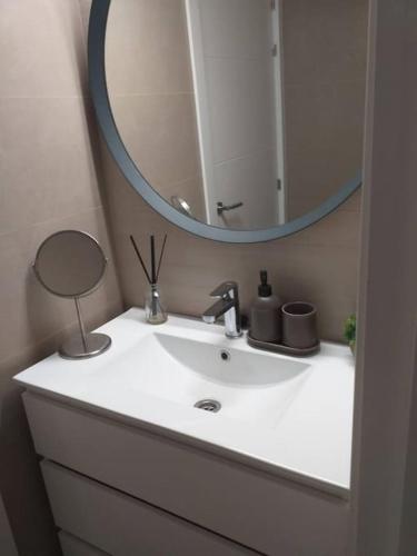 a bathroom with a white sink and a mirror at Precioso piso en Almería centro con parking gratis in Almería