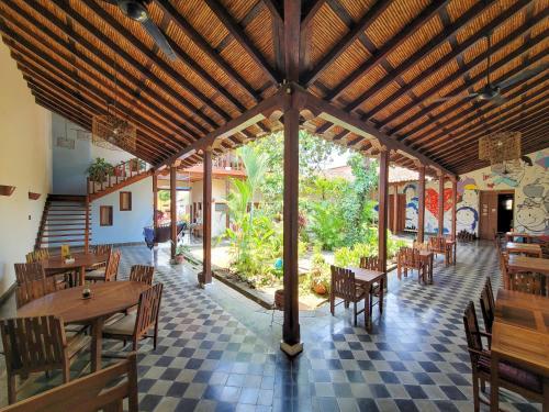 a restaurant with wooden tables and chairs and a checkered floor at Hotel con Corazón in Granada