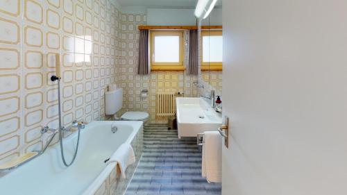 een badkamer met 2 wastafels en een bad bij Mulin in Celerina