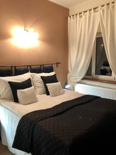 a bedroom with a large bed and a window at Folwark Nadmorska Ostoja in Mechelinki