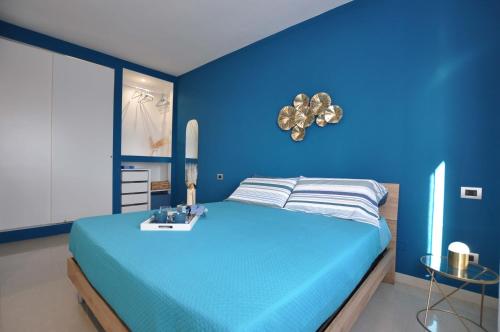 a blue bedroom with a bed with a blue wall at Dalila's Apartment in Sirmione