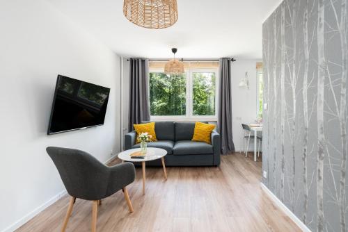 a living room with a couch and a table at Green View Apartment with Balcony Winogrady by Noclegi Renters in Poznań