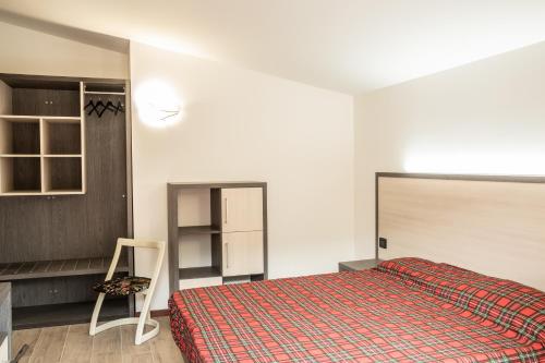 a bedroom with a bed and a chair in it at Appartamenti Edolo - A 20 minuti da Ponte di Legno e Aprica in Edolo